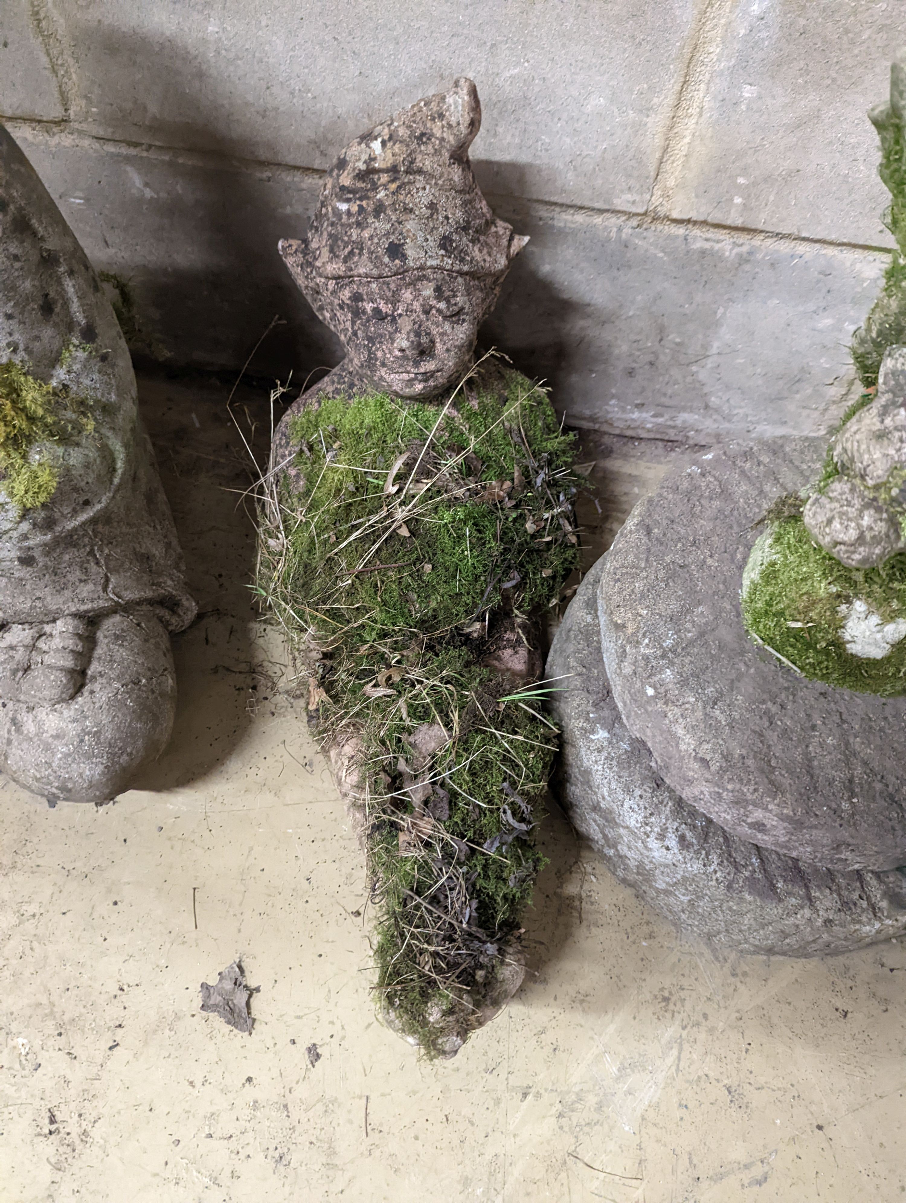 Two small circular mill stones, a reconstituted stone gargoyle and a terracotta reclining pixie garden ornament